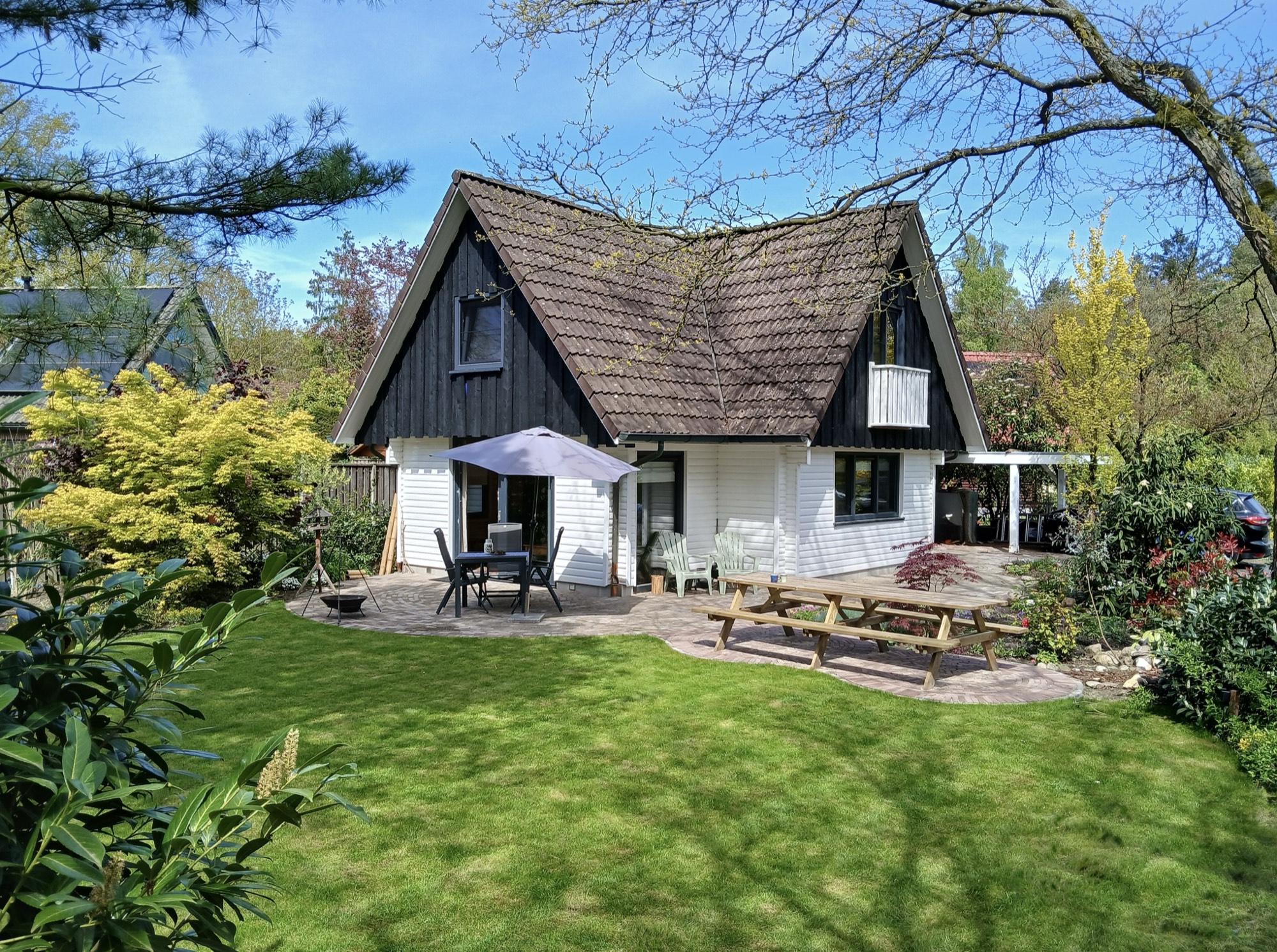 Het Bosatelier, een houten huisje met de tuin en picknicktafel in Winterswijk